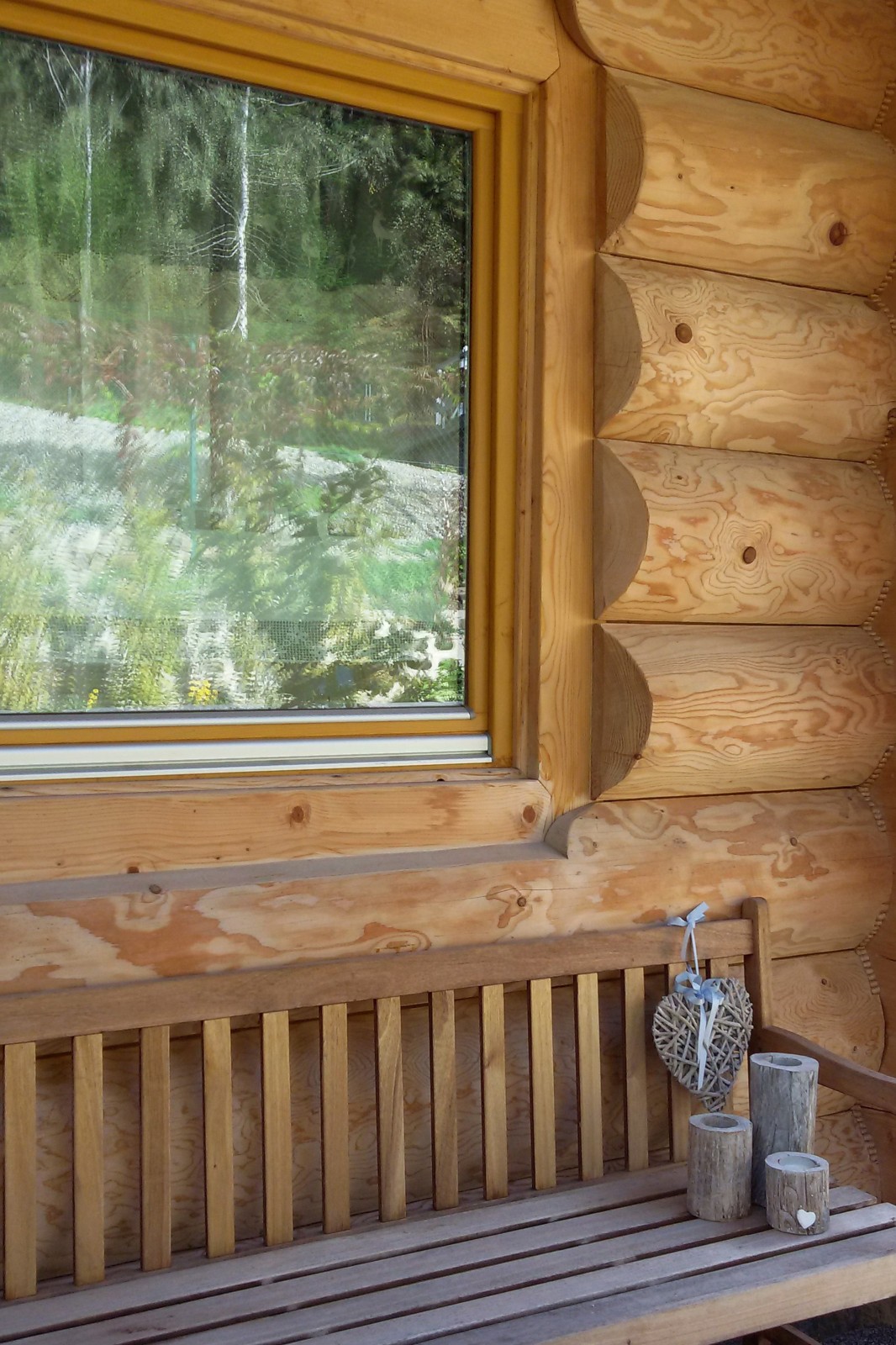 Lato Domy z bali na ławce przed domkiem
